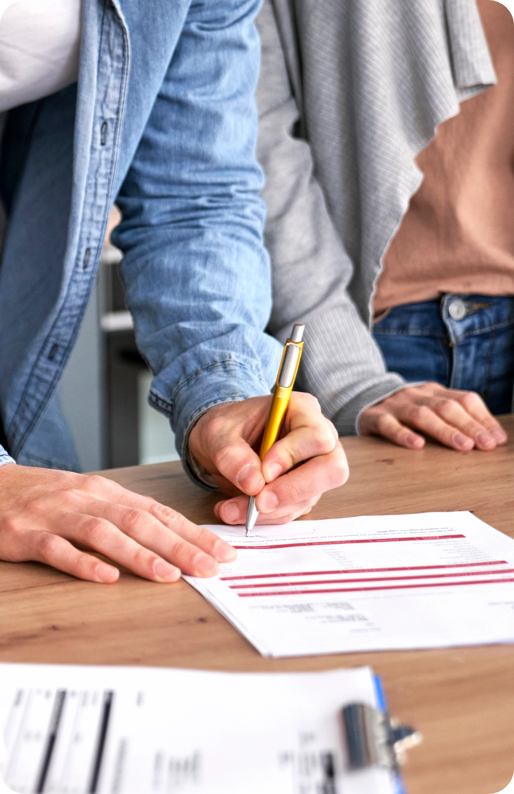 Couple_Signing_Contract_At_Table_Horizontal Couple Signing Contract At Table